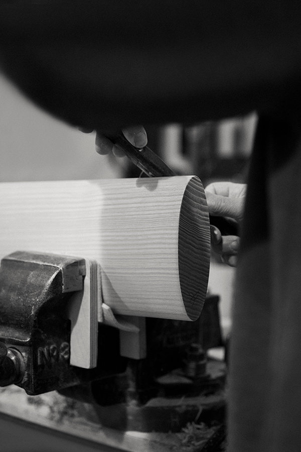 Greyscale image of a piece of wood held in a jig