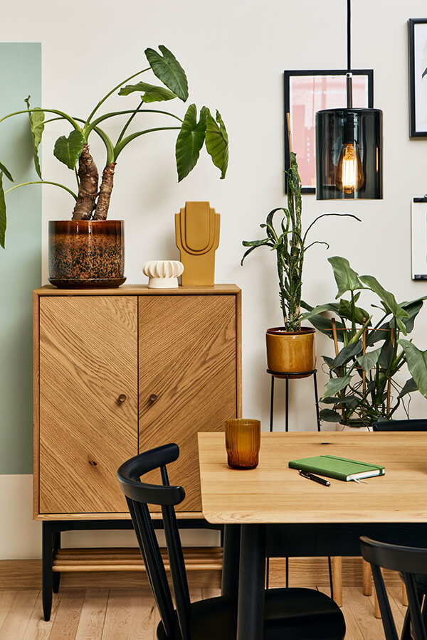 A cropped image of a Monza dining table and Heritage chair in front of a Monza universal cabinet