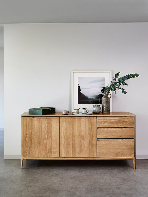 Romana large sideboard, with various items on top including a picture frame, green leafy plant, green box and tea set