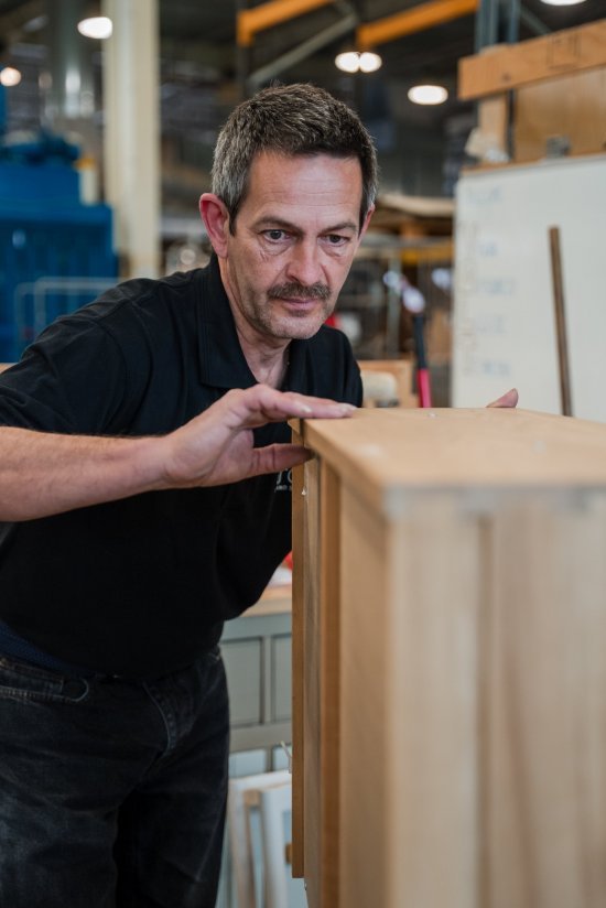 An ercol craftsman checking the careful construction of a piece of furniture within the factory
