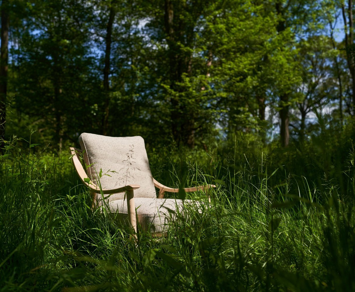 An ercol chair sits nestled in long grass