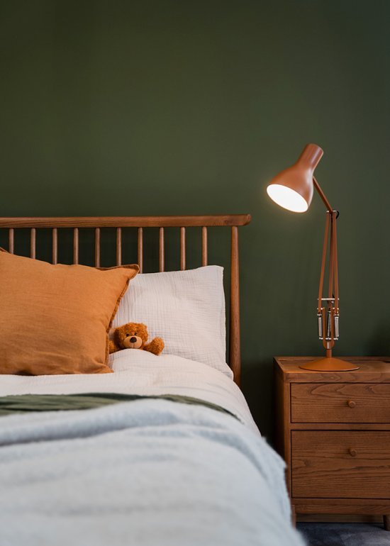 A teddy bear cosily tucked into an ercol Salina bed